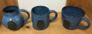 A set of Pendle Hill mugs in (L-R) round, straight, and bevel designs.